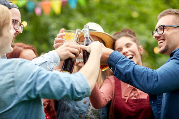 happy friends clinking glasses at summer garden