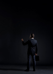 Businessman writing something over black background with copyspace. Business and office concept.