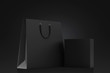 Black shopping bag and blank box on a black background. Mock up. 3d rendering