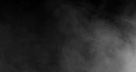 smoke slowly floating through space against black background