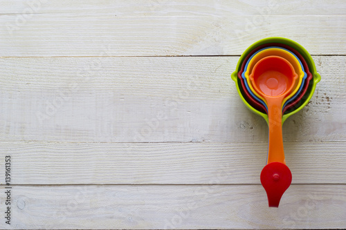 Fotografia, Obraz Colorful measuring spoons for kitchen on a white wooden background