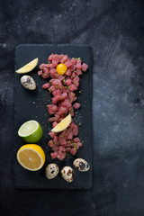 Wall Mural - Top view of tuna tartar on a dark scratched metal background, copyspace