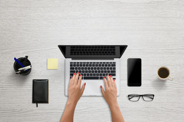 Aufkleber - Woman tap on laptop keyboard. Blank screen for mockup, design presentation. Modern office scene with black smart phone beside. Pad, coffee, glasses, pens beside.