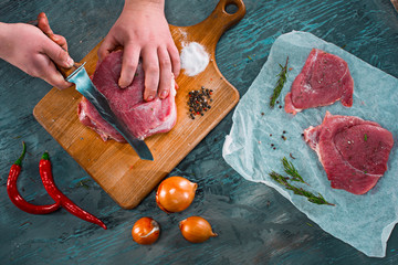 Butcher cutting pork meat on kitchen