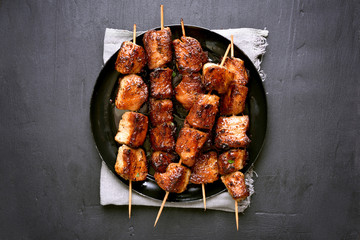 Wall Mural - Grilled pork kebabs on dark background, top view