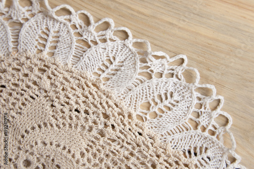 Fotografia, Obraz Knitted homemade white lacy doily on wooden background.
