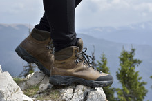 Hiking Boots On The Rock In The Mountains. Woman Hiker Stand On Mountain Peak Rock