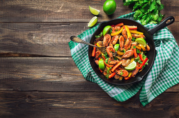 Fried shrimps with bell peppers, cilantro and lime