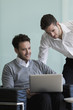 © PhotoAlto - Business colleagues using laptop in office