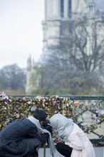 Couple Photographing Love Locks At Pont Des Arts, Paris, France