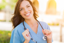 Portrait Of Young Adult Female Doctor Or Nurse Wearing Scrubs And Stethoscope Outside.