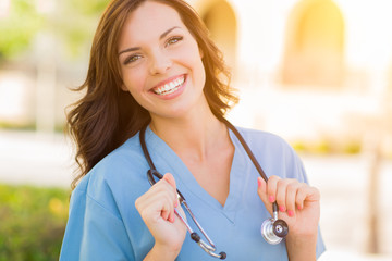 Portrait of Young Adult Female Doctor or Nurse Wearing Scrubs and Stethoscope Outside.