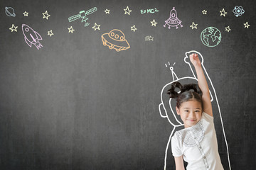 Creative innovation educational conceptual idea with happy little asian girl kid in astronaut suit doodle drawing, universe space out of earth planet on school class chalkboard chalk board background