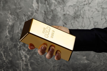 Hand with a gold bar