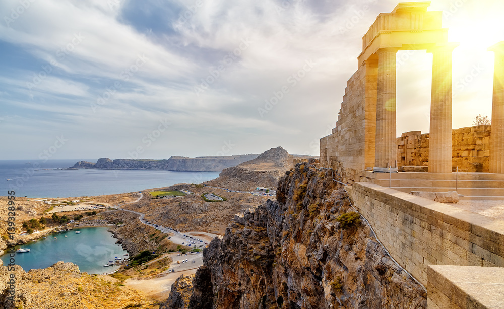 Greece. Rhodes. Acropolis of Lindos. Doric columns of the ancient Temple of Athena Lindia setting sun above the columns - obrazy, fototapety, plakaty 