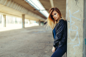 Wall Mural - Beautiful young woman posing in a black leather jacket