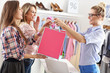 © Kalim - Female customer receiving shopping bags in boutique