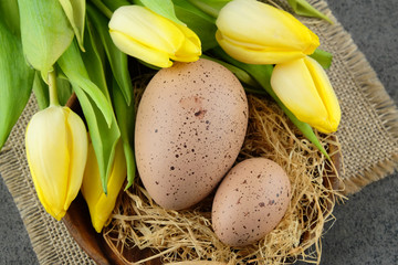 Wall Mural - Easter eggs and yellow tulips on burlap cloth.