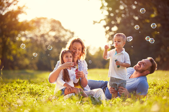 family with children blow soap bubbles outdoor
