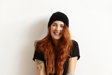 isolated studio portrait of fashionable female model with gorgeous long ginger hair looking and smil
