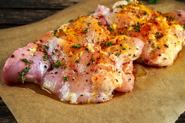 Wall Mural - Ready to cook free range raw boneless skinless chicken thighs on paper seasoned with sea salt, garlic and pepper