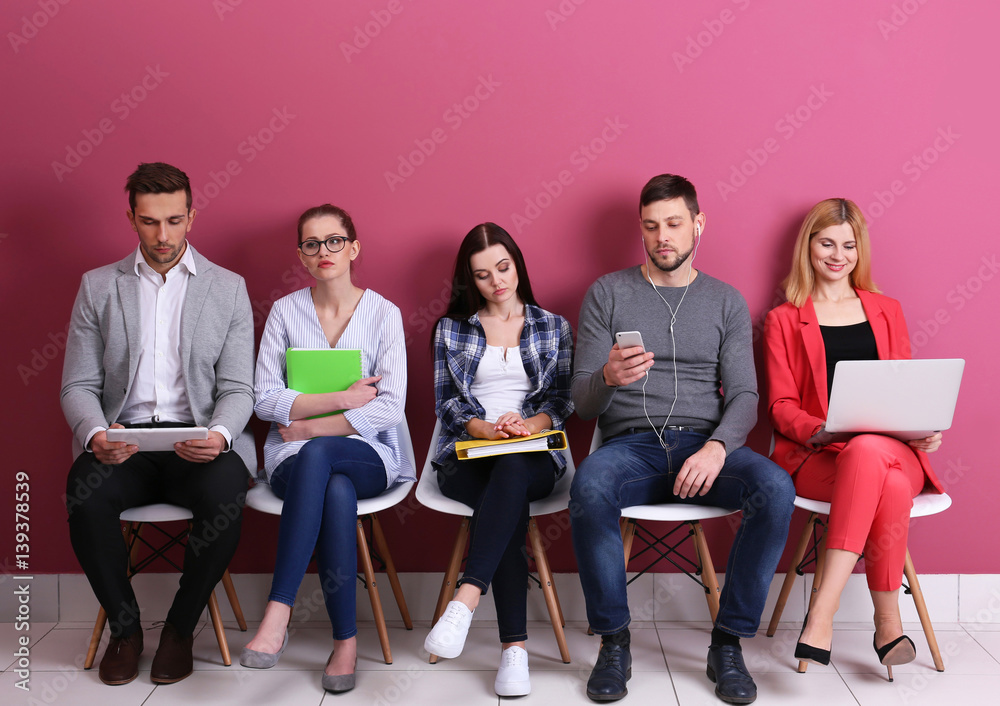 Group of people waiting for job interview on colour background