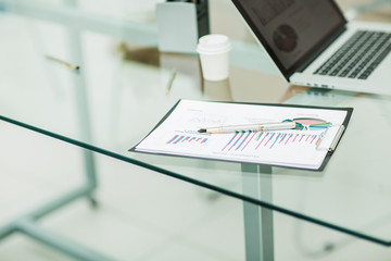 financial chart,pen and notebook at the workplace of the busines