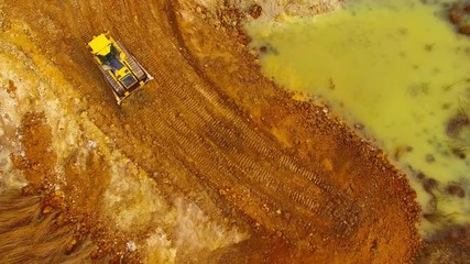Wall Mural - Aerial view of bulldozer on muddy construction site or dump. Heavy industry from above. Industrial background from devastated landscape.