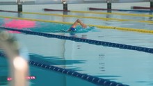 Female Swimmer Swims In Pool HD Video. Crawl Freestyle Training. Professional Woman Athlete On Water Lane.