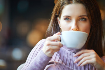 Canvas Print - Beautiful young woman with a cup of tea at a cafe