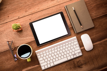 mockup tablet similar to ipad style on wood desk white display.keyboard and office stuff, workplace, top view