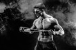 Portrait of muscular sportsman tearing metal chain.Black background with smoke