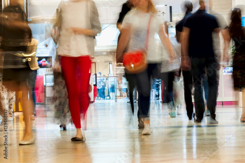 Fotografía Abstract defocused motion blurred young people walking in the shopping center, urban lifestyle concept