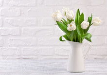 Fresh White Tulip Flowers Bouquet In Front Of White Brick Wall.