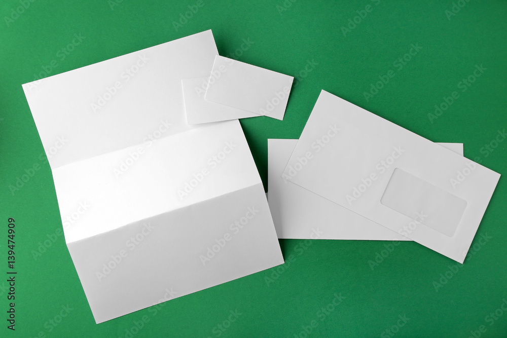 Blank brochure, envelope and card on green background