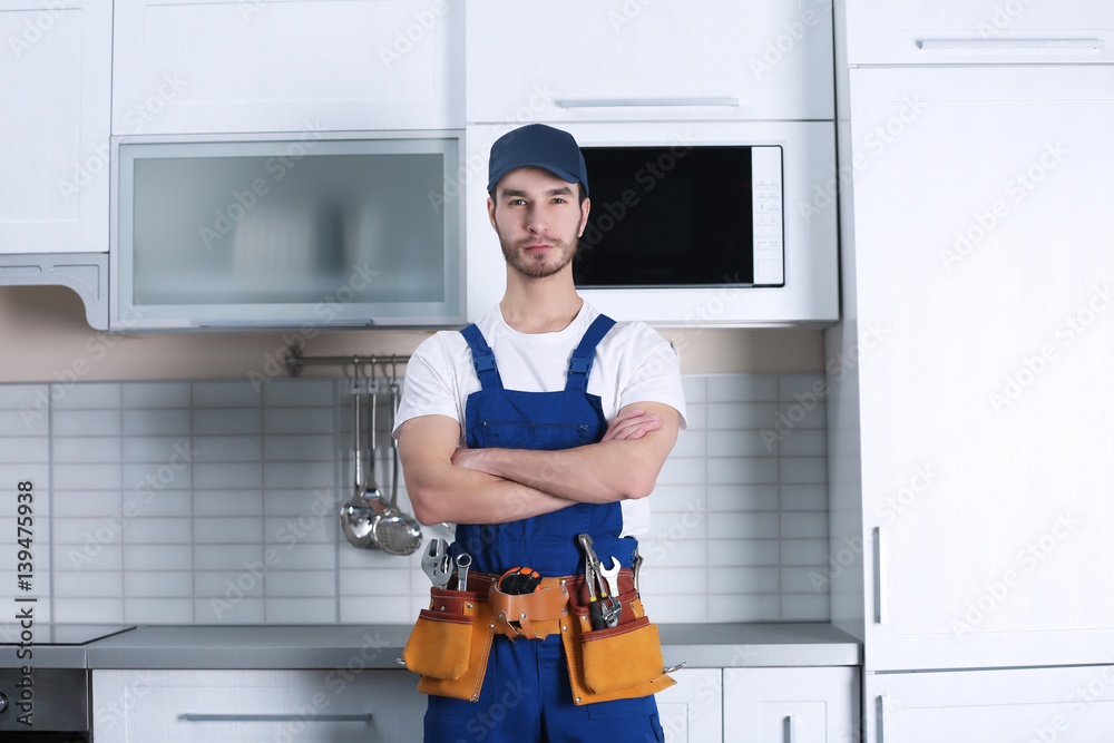 Handsome young worker in kitchen