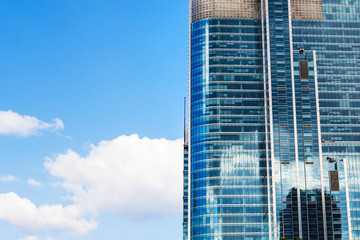 Modern glass skyscraper business center in the process of finishing the facade of glass