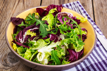 Canvas Print - Frise, batavian, radichchio, arugula in a ceramic bowl on a wood