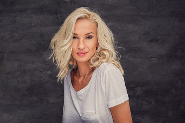 Portrait of blond female over grey background.