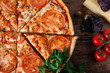 Delicious hot pizza sliced and served on wooden table with ingredients, top view. Italian restaurant menu photo.