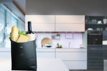 Shopping for cooking, healthy eating. Paper bag with delivered food products - cheese, bread, green salad, wine on kitchen table. Kitchen background. Concept of shopping, cooking, eating, Copy space