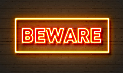 Wall Mural - Beware neon sign on brick wall background.