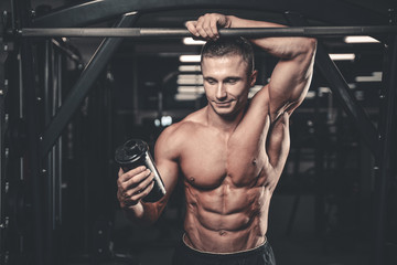 Muscular Man Resting After Exercise And Drinking From Shaker