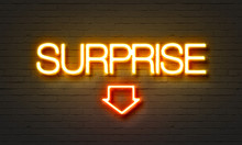 Surprise Neon Sign On Brick Wall Background.