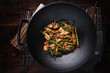 stir fried chicken in cast iron wok in flat lay composition