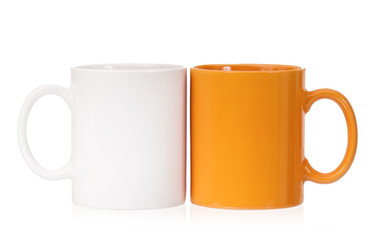 Orange and white mugs empty blank for coffee or tea isolated on white background 