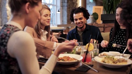 Wall Mural - happy friends eating and drinking at restaurant