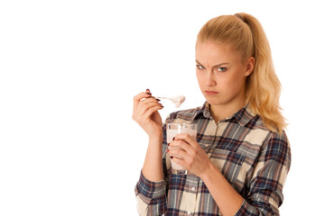 Wall Mural - Cute blonde woman eating fruit yogurt isolated over white background