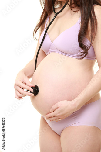 お腹に聴診器をあてる臨月の妊婦 Stock Photo Adobe Stock