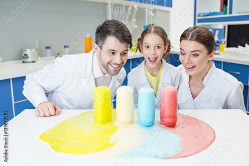 Fotografie, Obraz portrait of cheerful teachers and girl student scientists making experiment in l